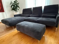 Ecksofa Avalanche Stoff 8145 Dunkelgrau mit 3 Lendenrollen und einem Hocker